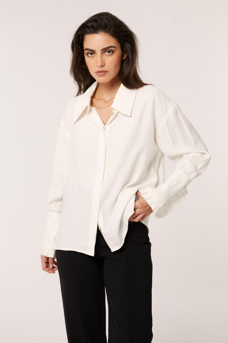 White Señorita Antonia blouse with long sleeves and button front, displayed on a hanger against a neutral background.