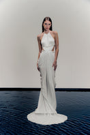 White VEYA gown by Francisco Arce, elegant floor-length dress with flowing fabric and detailed neckline, perfect for formal occasions.