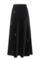 Black rose embroidered midi skirt by DELEGAN, featuring intricate floral embroidery and a flowing midi length.