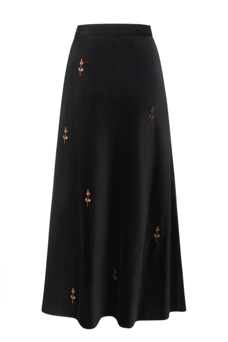 Black rose embroidered midi skirt by DELEGAN, featuring intricate floral embroidery and a flowing midi length.