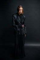 Black textured leather jacket by Vaska, featuring a stylish design and detailed craftsmanship, displayed on a hanger.