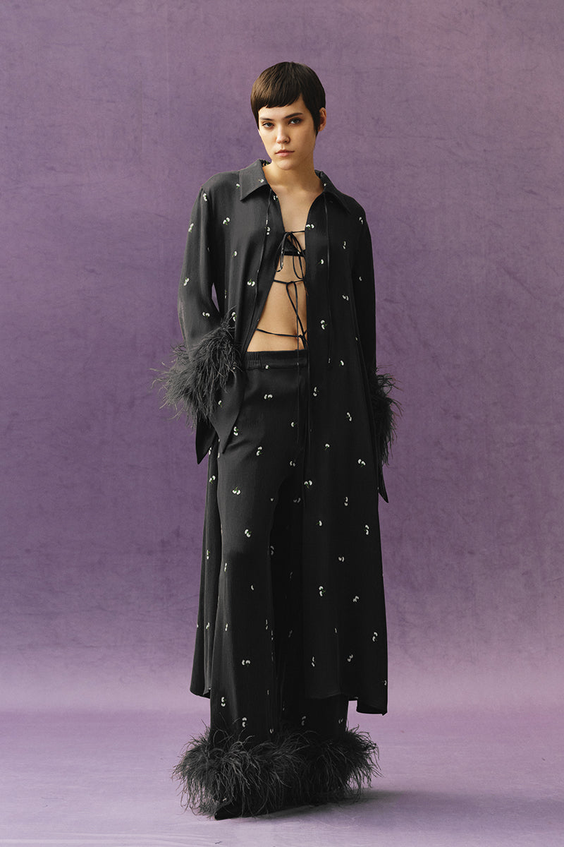 Sayya black pants with feather details, slim fit design, shown on a model with a stylish, contemporary look.