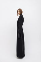 Black Vaska long trench jacket with zippers, featuring a sleek design and modern style, shown on a model.