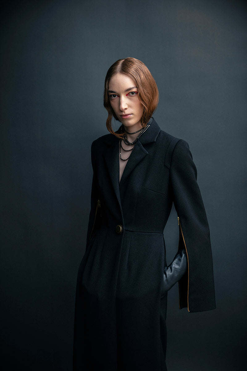 Black Vaska long trench jacket with front zippers, showcasing a sleek and stylish design perfect for modern outerwear.
