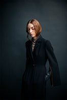 Vaska black long trench coat with zippers, stylish and modern jacket shown in the image.