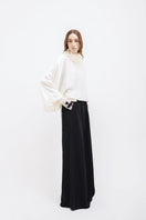 Black Vaska wide-leg pants with belted waist, flowing fabric, and relaxed fit, displayed on a neutral background.