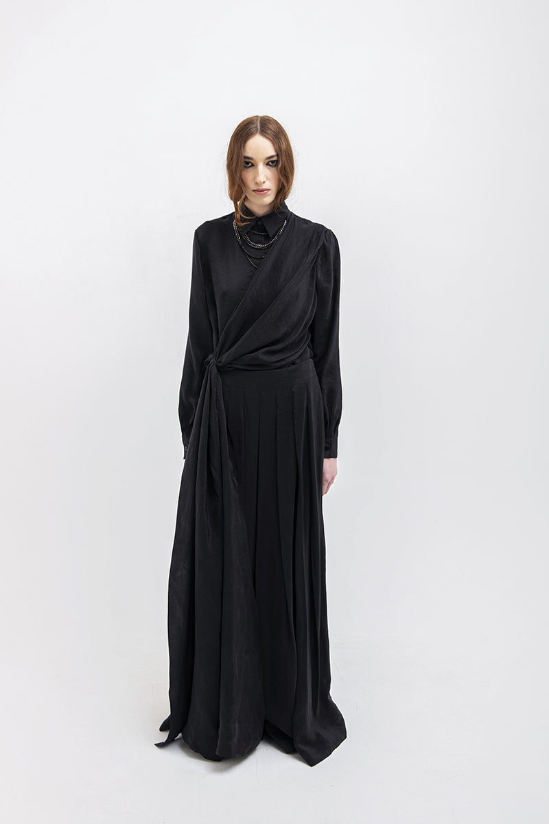 Black Vaska wide leg pants shown on a model, featuring a relaxed fit, high waist, and flowing fabric for a stylish casual look.