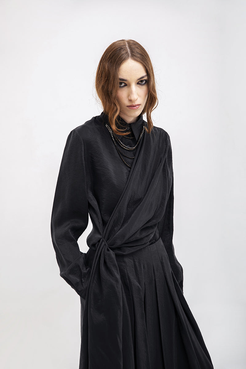 Black Vaska wide leg pants displayed on a hanger, showcasing their relaxed fit and flowy fabric.