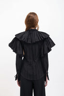 Black Vaska shirt with a large collar, featuring a stylish and modern design, shown on a model.