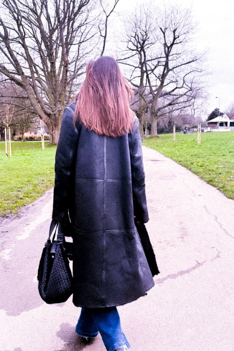 Black Zina biker shearling coat by Verheyen, featuring a stylish biker design with a plush shearling collar and sleek silhouette.