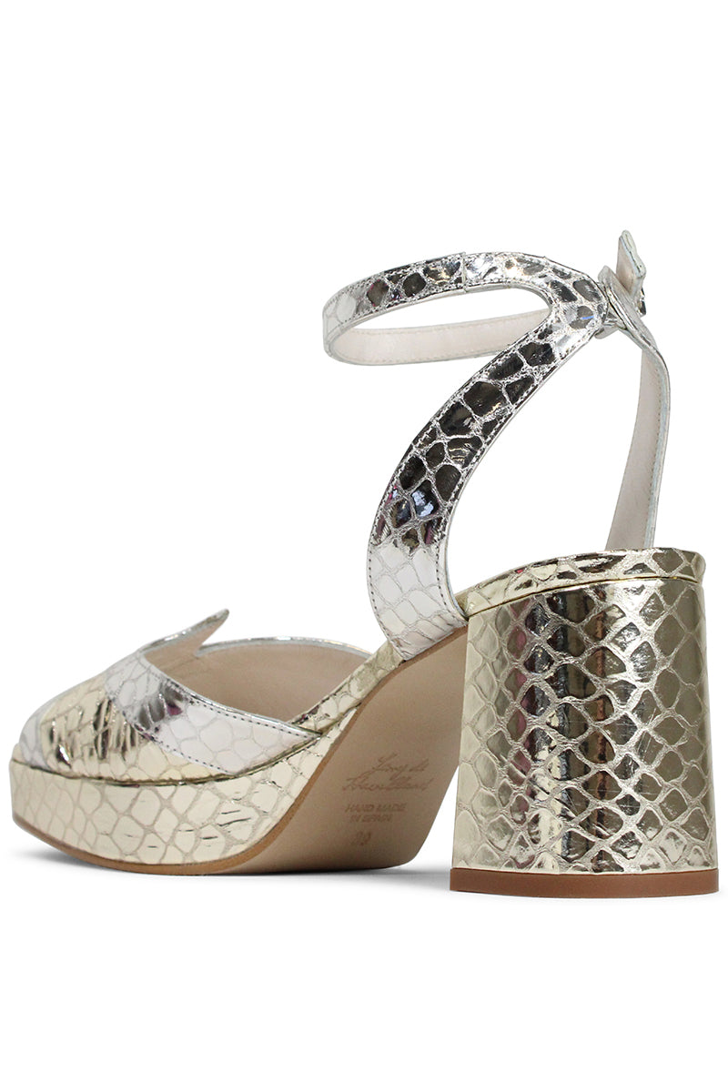 Terry de Havilland Sima block heels showing beige textured leather with chunky heel and ankle strap on a neutral background.