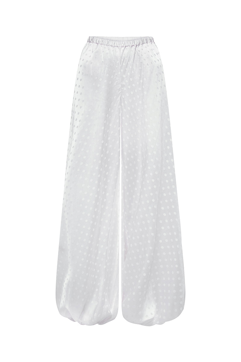 Nué Solange white pants displayed on a model, showcasing a stylish and comfortable fit in a casual fashion style.