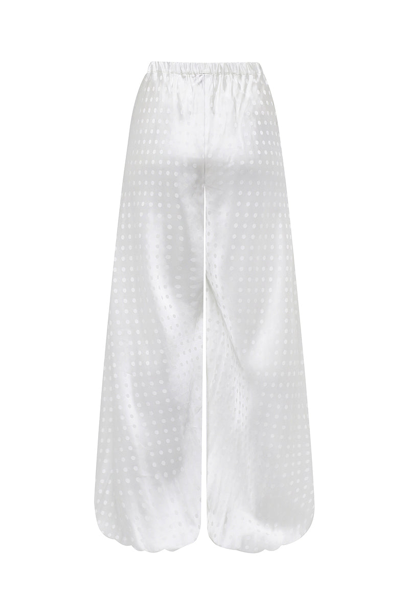 Nué Solange white pants shown on a model, featuring a sleek, tailored fit and smooth fabric for a stylish, modern look.
