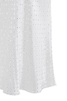 White Nué Veronique midi skirt displayed on a hanger, showcasing its flowy fabric and elegant length.