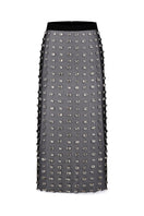 Black Nué Chantal midi skirt displayed on a model, showcasing its elegant, flowing design and versatile length.