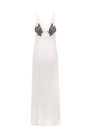 Nué Perla white maxi dress displayed on a hanger, showcasing elegant flowing fabric and effortless summer style.