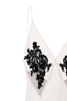 Nué Perla white maxi dress displayed on a hanger, featuring flowing fabric and elegant design ideal for summer or special occasions.