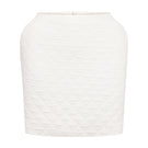 White Nué Margot mini skirt displayed on a hanger with a plain background, showcasing its sleek, fitted design.