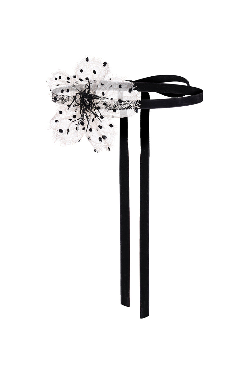 White polka-dot choker necklace by Nué featuring a stylish, adjustable design with playful polka dot pattern.