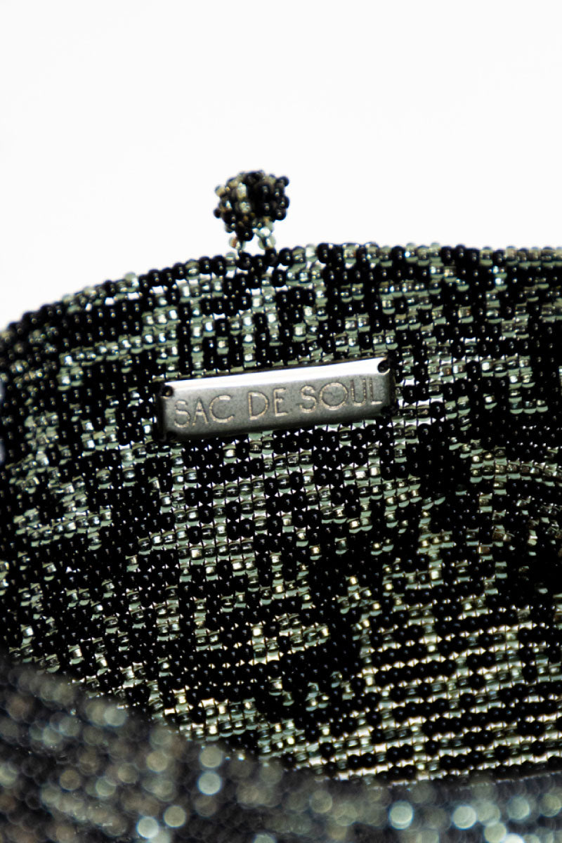 Inside view of SAC DE SOUL Nina top handle bag in black, white, purple, and green with colorful interior details.