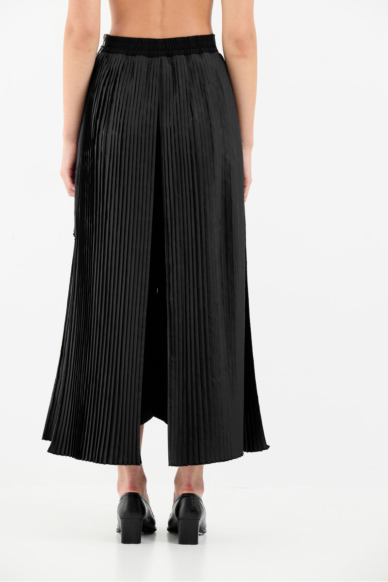 Black Tamar Keburia IDA culottes pants with wide-leg design and high waist, shown on a model in a stylish indoor setting.