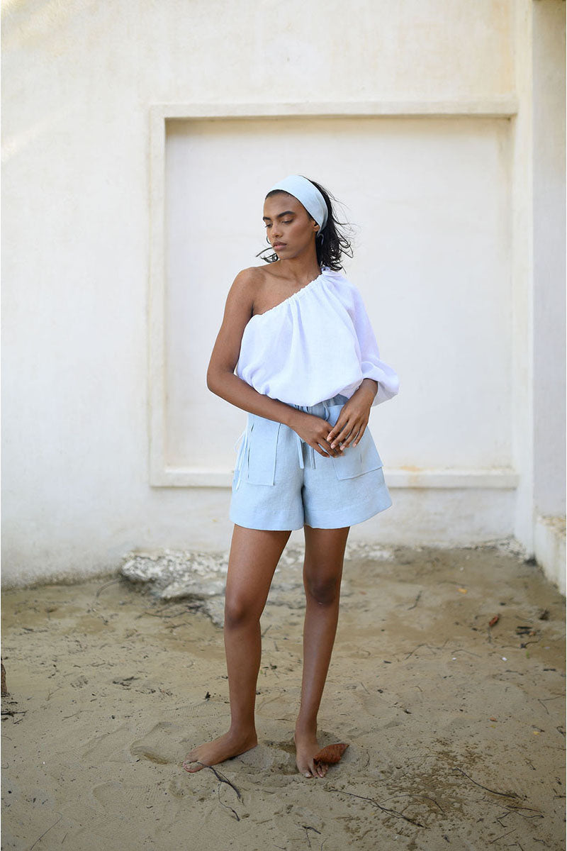 Light blue ANA + MARIA ILLA shorts laid flat, showing the casual fit and fabric texture of these stylish summer shorts.
