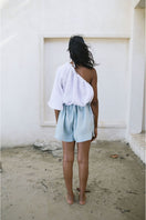 Light blue ANA + MARIA Illa Shorts displayed flat, showcasing their casual fit and soft fabric for comfortable summer wear.