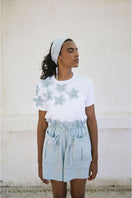 Light blue ANA + MARIA ILLA shorts displayed on a model, showcasing casual fit and stylish summer fashion.