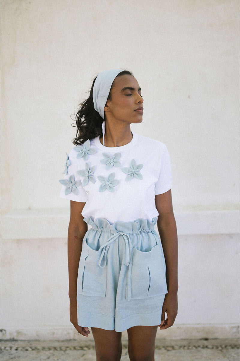 Light blue ANA + MARIA ILLA shorts displayed on a model, showcasing casual fit and stylish summer fashion.