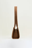Poelle Cecilie top handle bag in caramel leather, showcasing its elegant design and structured shape.