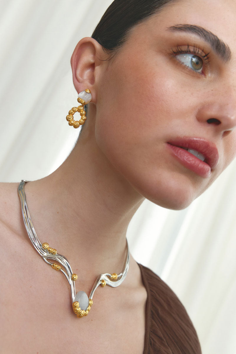 Jude Benhalim interchangeable bloom earrings with colorful floral designs and gold-tone settings on a white background.