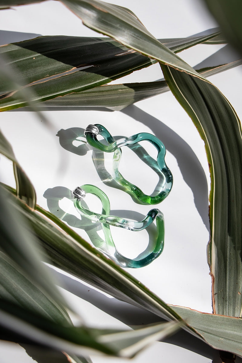 Salvária Interconexión L earrings in vibrant green with interconnected loop design, stylish jewelry accessory.