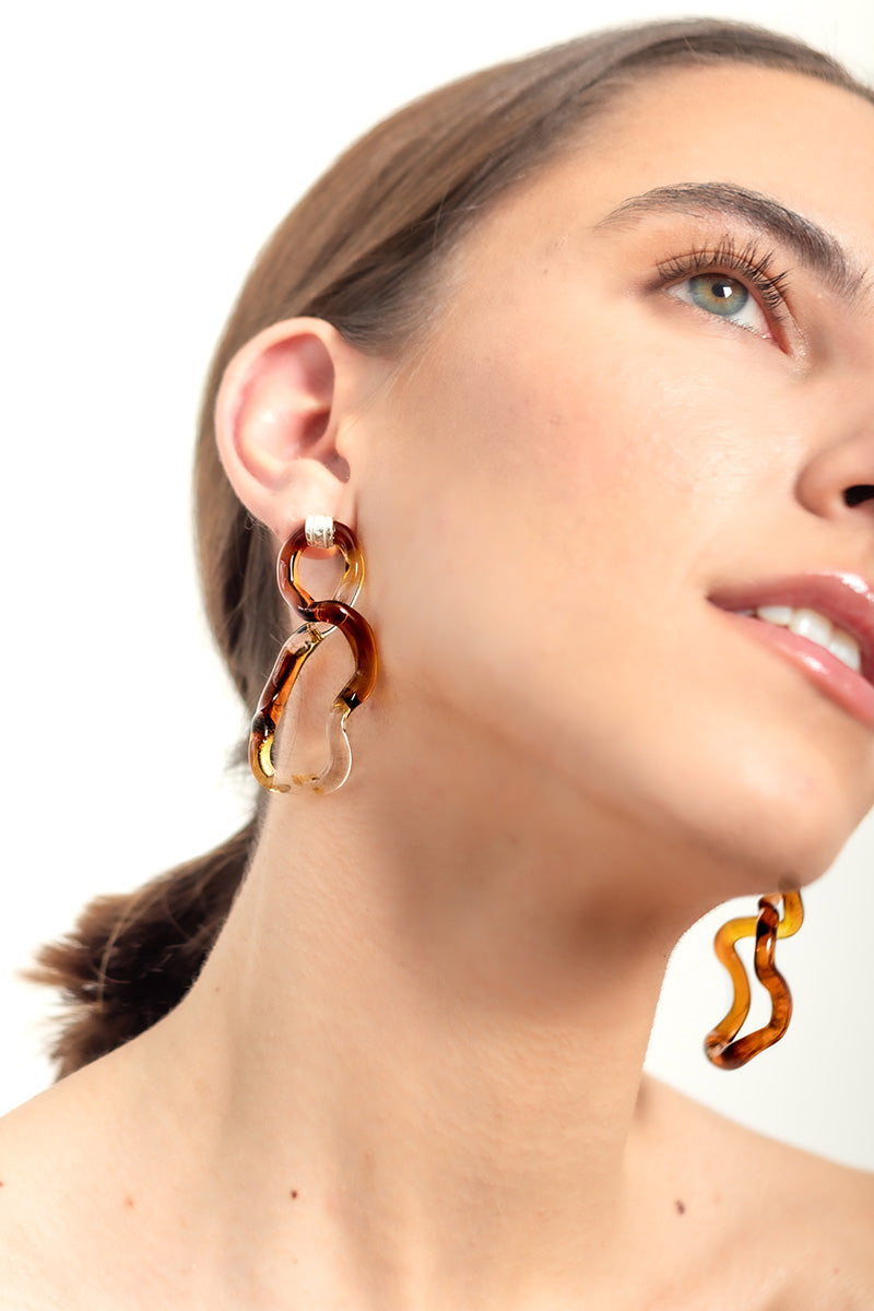 Salvárea amber interconnection L-shaped earrings featuring warm amber stones and elegant gold-tone metal design.