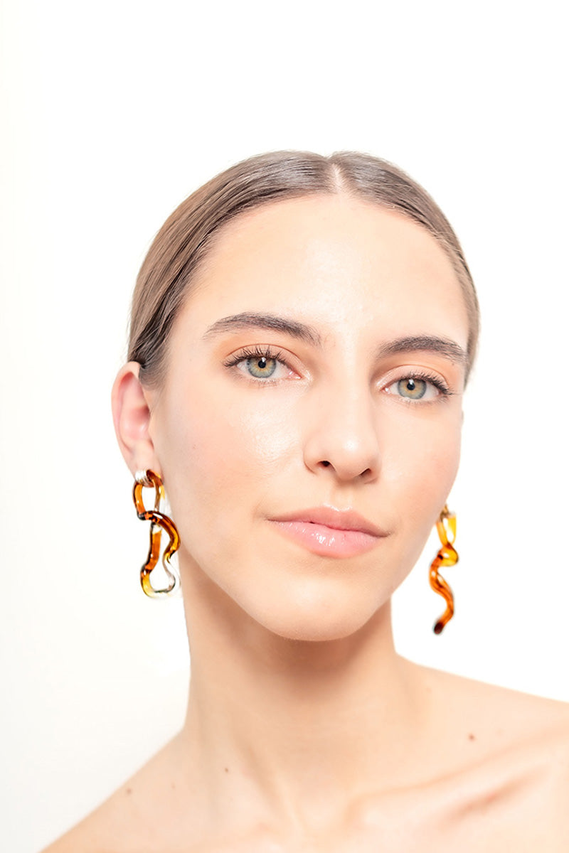 Salvária interconnection L earrings in amber with intricate design and gold-tone hooks, showcasing elegant jewelry craftsmanship.