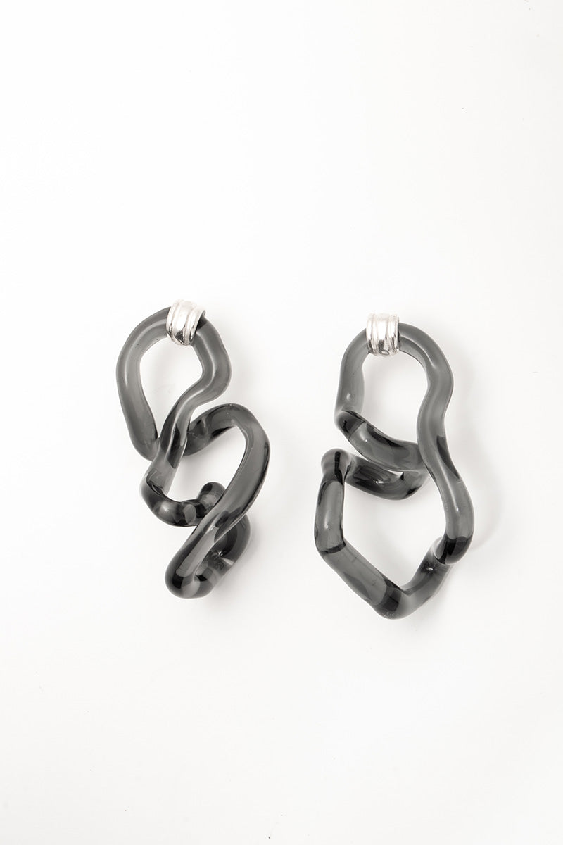 Salvárea Interconexión L earrings in smoke-colored metal, featuring a sleek, modern design with interconnected geometric shapes.