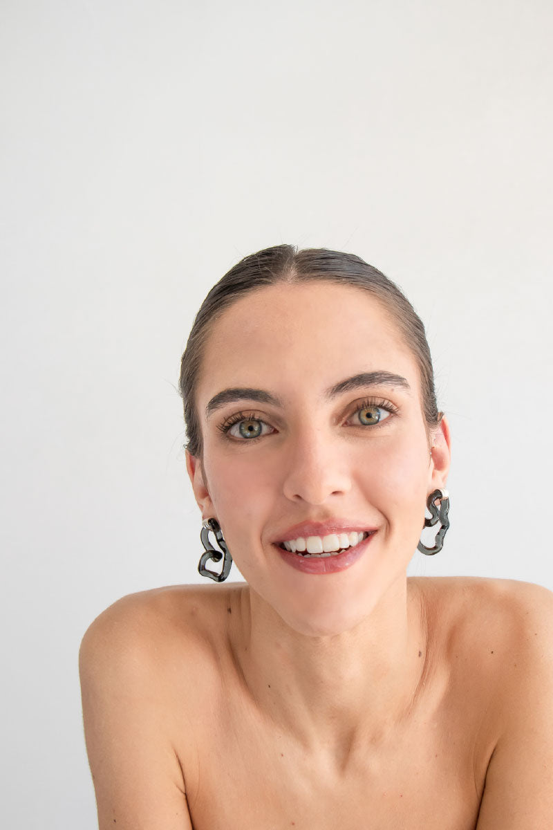 Salvárea Interconexión M earrings in smoky, translucent material with a modern, geometric design.