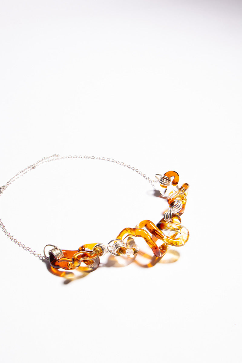 Salvária interconnection necklace featuring a warm amber pendant on a delicate chain, showcasing elegant jewelry design.