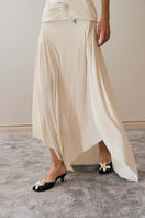 Close-up of YASSMIN SALEH ivory intersect midi skirt showing textured fabric and stylish design details.