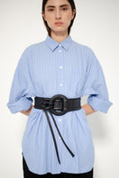Black Isidora Malva Belen belt with sleek design and subtle branding, shown styled in a lookbook setting.