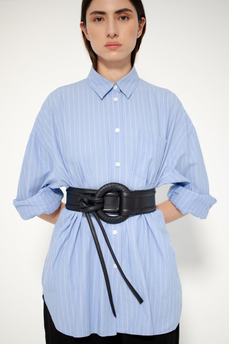 Black Isidora Malva Belen belt with sleek design and subtle branding, shown styled in a lookbook setting.