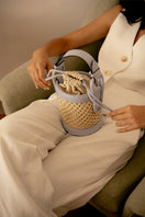 Blue IZA bucket top handle bag by ISIDORA MALVA with a rounded shape and stylish design, shown in a lookbook image.