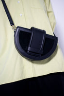 Black leather and suede Luna clutch by Isidora Malva featuring a sleek, compact design with a textured finish.