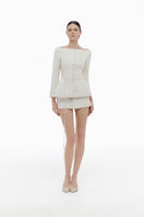 Ivory brocade blazer by Montsand with intricate floral patterns, paired with a matching skirt for elegant formal wear.