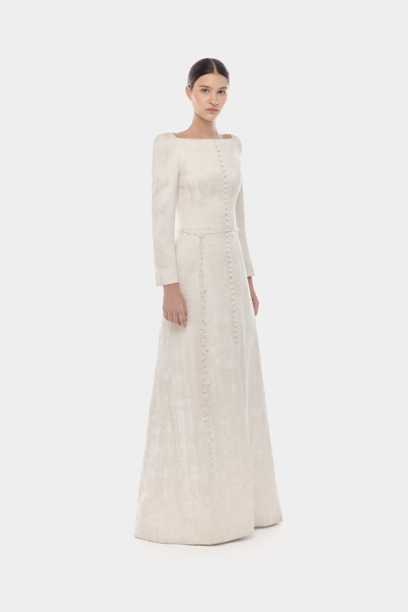 Elegant ivory brocade split maxi dress by Montsand featuring intricate fabric and flowing design for formal occasions.