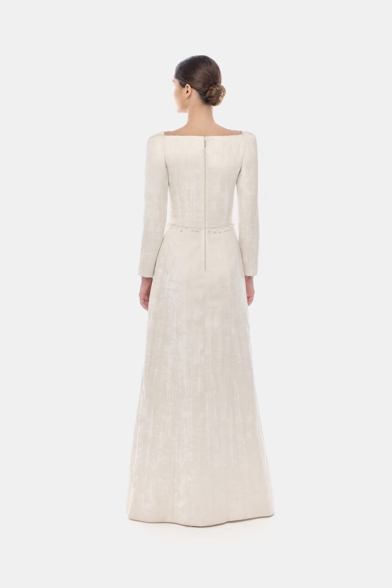 Elegant ivory brocade split maxi dress by Montsand, featuring intricate design and flowing silhouette for formal occasions.