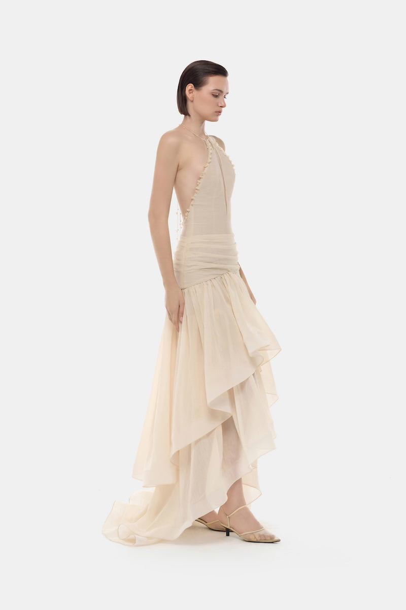 Ivory cut-out halter maxi dress by Montsand featuring a flowing silhouette and stylish cut-out details at the waist.