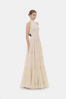 Elegant ivory tiered halter gown by Montsand featuring flowing fabric and a stylish, layered maxi design.