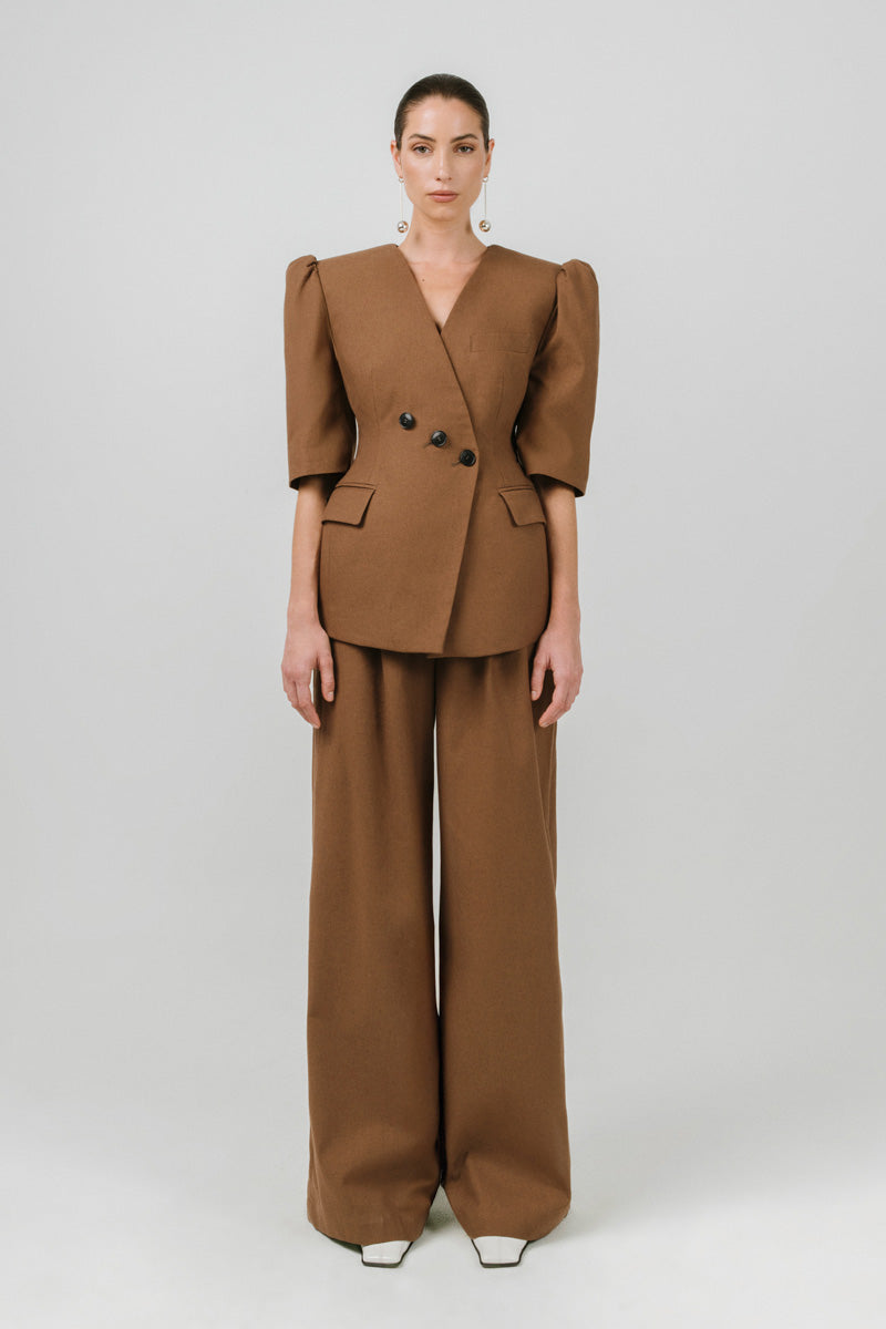 Izakova Tessa pants in brown, stylish women's pants with a tailored fit and smooth fabric, displayed on a white background.