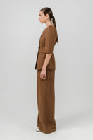 Izakova TESSA brown pants featuring a tailored fit and stylish design, displayed on a hanger.
