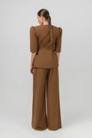Izakova Tessa pants in brown, stylish tailored pants with a slim fit and front pockets, shown on a model.